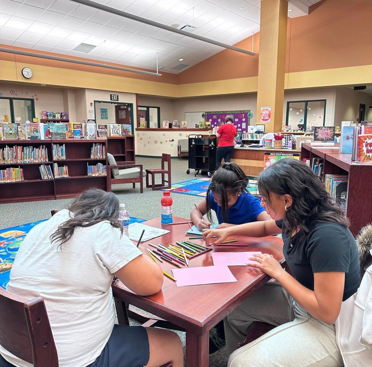 Tutors and students working on a creative project together at a classroom table