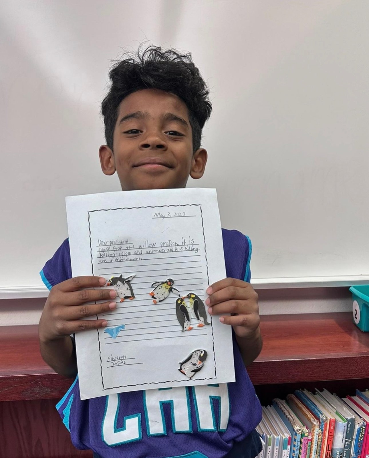 A student holding up his finished story