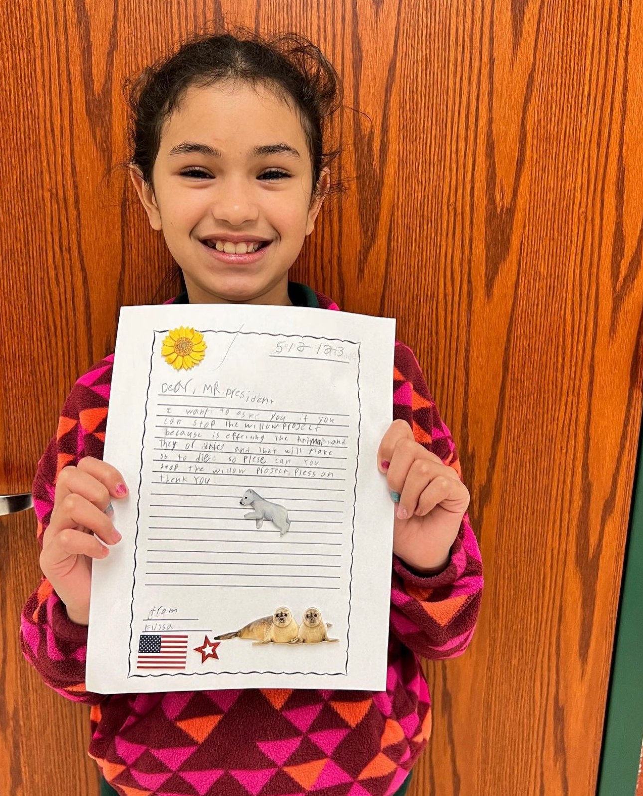 A student beaming with her finished letter