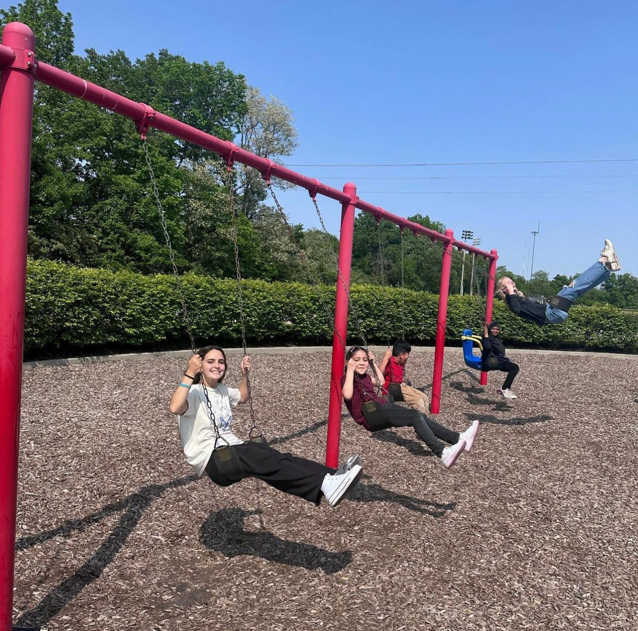 A tutor and students on the swings