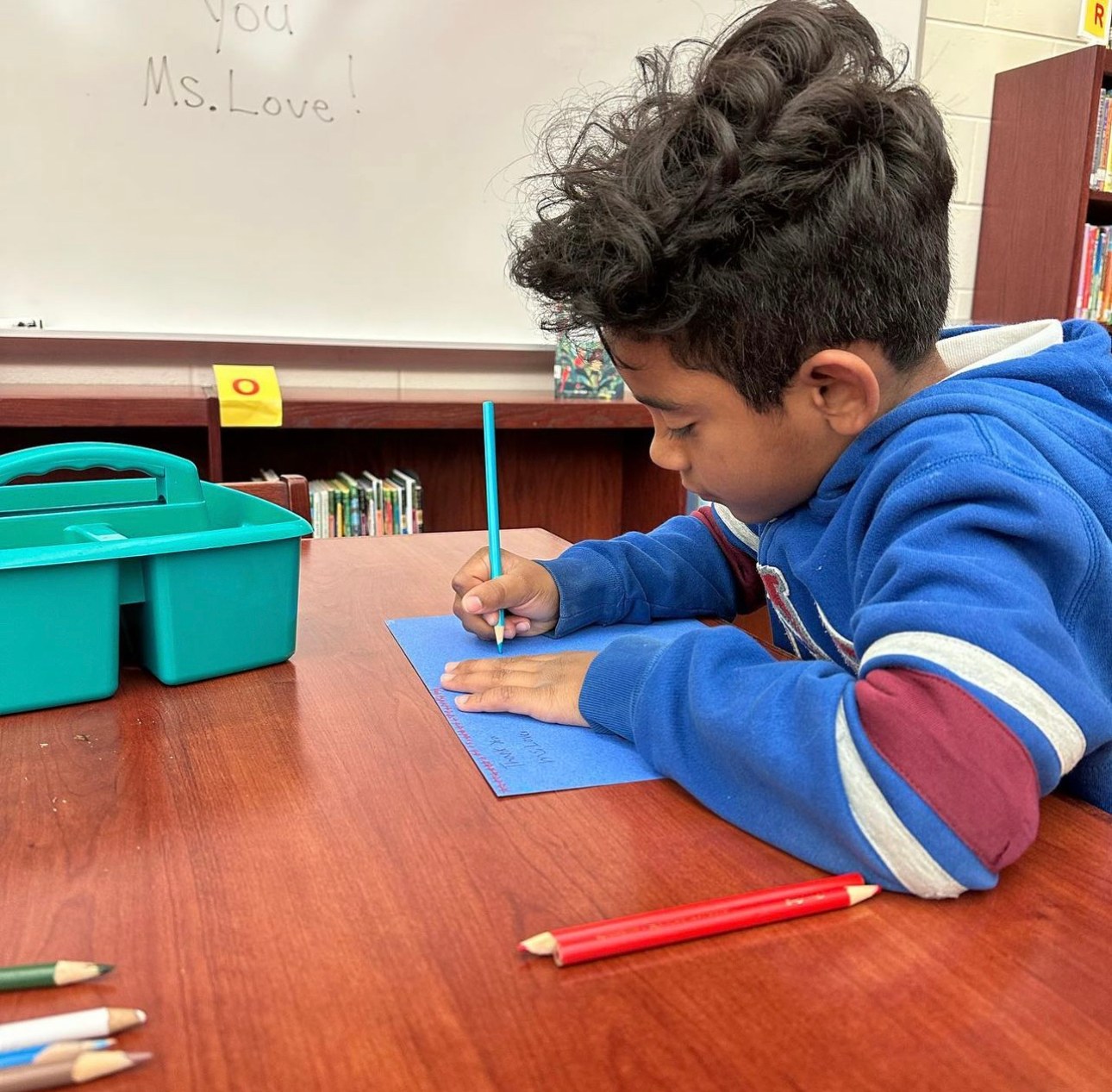 An elementary student concentrating on a writing exercise